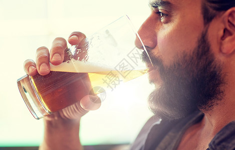 人,饮料,酒精休闲近距离的轻人喝啤酒璃酒吧酒吧靠近酒吧酒吧喝啤酒的人靠近酒吧酒吧喝啤酒的人背景图片