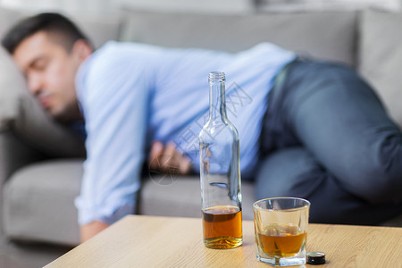 男人与酒素材酒精成瘾人们的瓶子与杯威士忌桌子上熟睡的醉汉瓶酒桌子上熟睡的醉汉瓶酒桌子上熟睡的醉汉背景