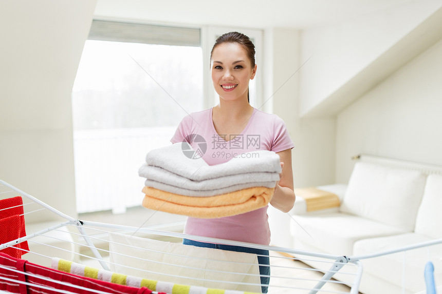 洗衣家庭快乐的女人家庭主妇与干燥架,浴巾干燥架家里家里浴巾晾衣架的女人家里浴巾晾衣架的女人图片