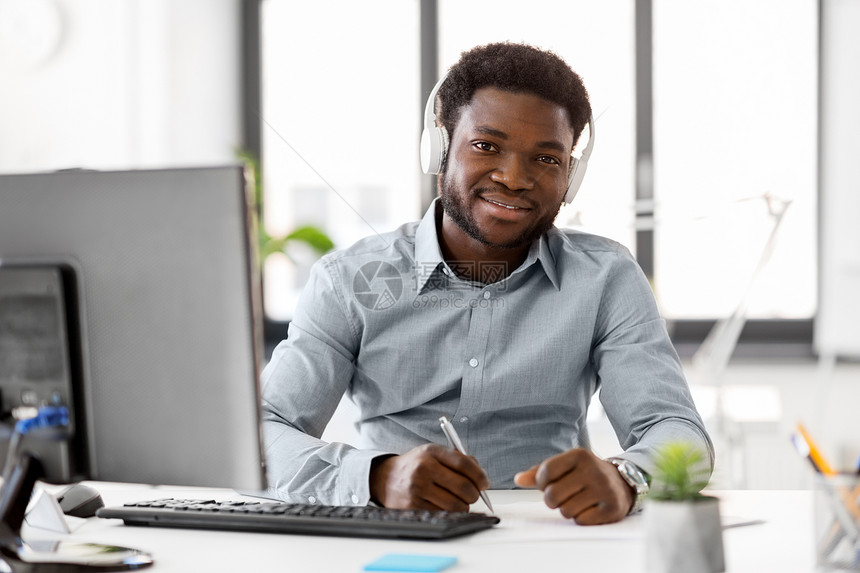 商业,技术人的快乐的非裔美国商人戴着耳机报纸办公室听音乐办公室戴耳机报纸的商人办公室戴耳机报纸的商人图片