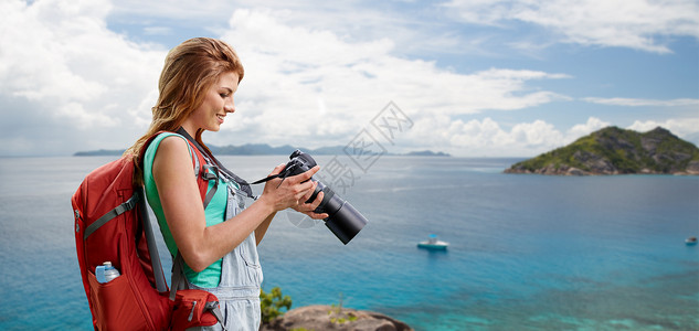 海滩上女人带着背包相机旅行摄影背景图片