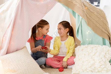 童潮湿的快乐的小女孩玩具陶器孩子们的帐篷家里小女孩家孩子们的帐篷里玩茶话会小女孩家孩子们的帐背景图片