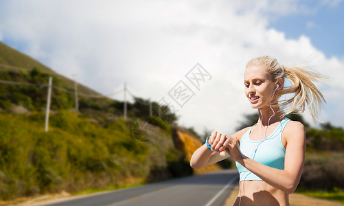 跑步路线运动,技术健康的生活方式微笑的轻妇女与健身跟踪器耳机锻炼大丘道路背景加利福尼亚健身追踪器的女人户外运背景