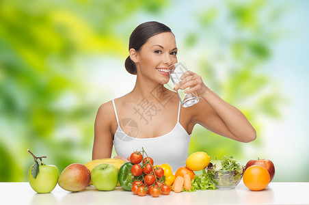 饮食,健康饮食人的妇女与食物桌子上饮用水绿色自然背景健康食物的女人桌子上喝水健康食物的女人桌子上喝水背景图片