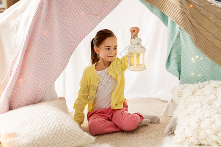 带座灯笼童潮湿的快乐的小女孩带着诞灯笼孩子们的帐篷里家孩子们家里的帐篷里灯笼的小女孩孩子们家里的帐篷里灯背景