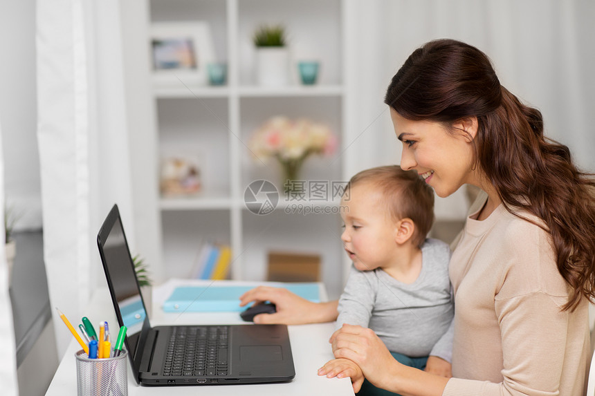 母亲,多任务,家庭人的快乐的母亲与婴儿笔记本电脑家里工作快乐的母亲带着孩子笔记本电脑家工作快乐的母亲带着图片