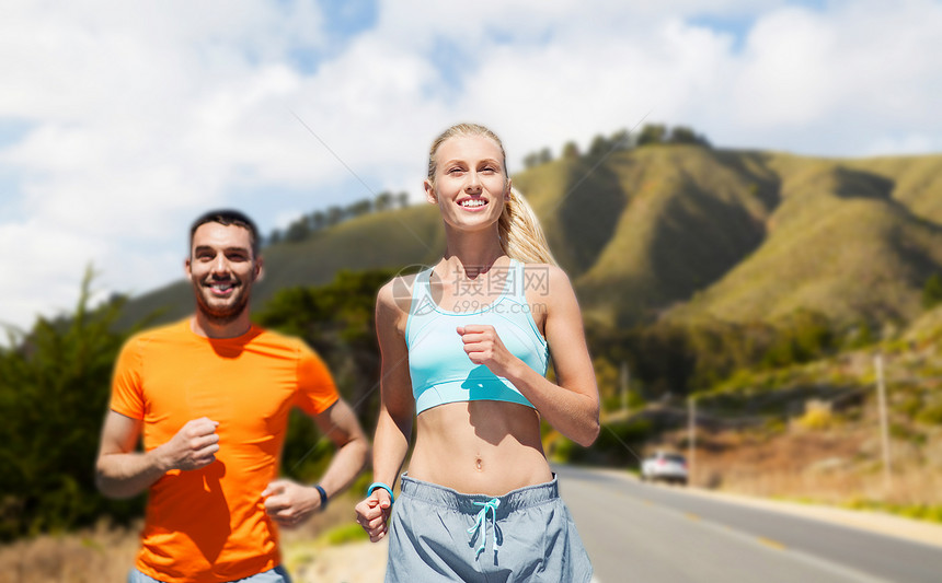 健身,运动健康的生活方式微笑的夫妇跑过大苏尔山道路背景加利福尼亚微笑的夫妇跑过大丘微笑的夫妇跑过大丘图片