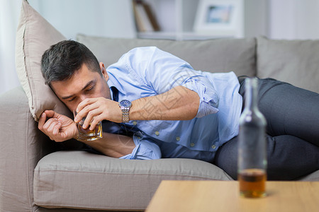 酗酒,酗酒人的男酗酒者躺沙发上喝威士忌酒鬼躺沙发上喝威士忌酒鬼躺沙发上喝威士忌图片