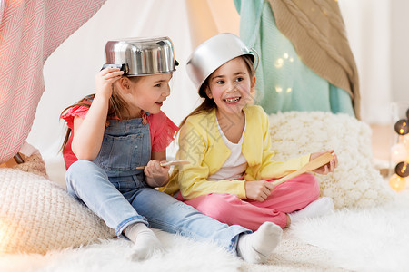 童潮湿的快乐的小女孩家里的孩子帐篷里玩炊具带厨房用具的女孩家里的帐篷里玩带厨房用具的女孩家里的帐篷里玩背景图片