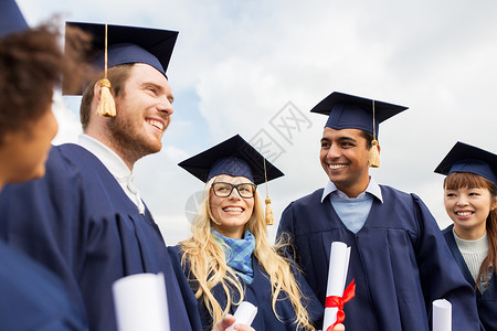 图文快印教育毕业人的群快乐的国际学生穿着迫击炮板学士学位礼服与文凭文凭的迫击炮板上快乐的学生文凭的迫击炮板上快背景