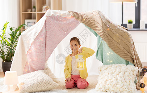 小桔灯童潮湿的快乐的小女孩带着诞灯笼孩子们的帐篷里家孩子们家里的帐篷里灯笼的小女孩孩子们家里的帐篷里灯背景