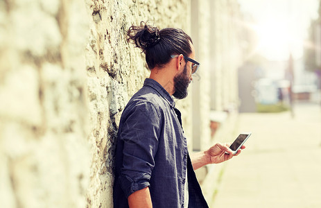 手机墙素材休闲技术通信人的街上的石墙上用智能手机接近人类石墙上用智能手机男人石墙上用智能手机男人背景