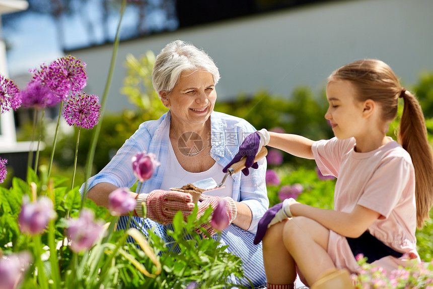 园艺,家庭人的快乐的祖母孙女夏季花园种花祖母女孩花园里种花祖母女孩花园里种花图片