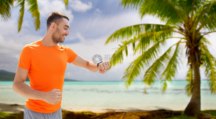 运动,技术健康的生活方式微笑的轻人与智能手表健身跟踪热带海滩背景法属波利尼西亚智能手表健身追踪器的人图片
