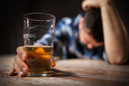 酒精中,酒精的男酒精与杯啤酒躺桌子上晚上睡觉晚上桌子上喝了杯酒的醉汉图片
