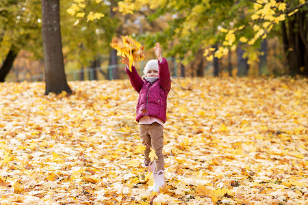 童,季节人的快乐的小女孩秋天的公园玩落叶快乐的女孩秋天的公园玩树叶图片