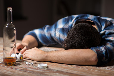 晚上躺桌子上的瓶酒精药丸的用酒精过量服药背景图片