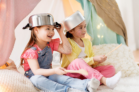 童潮湿的快乐的小女孩家里的孩子帐篷里玩炊具带厨房用具的女孩家里的帐篷里玩背景图片