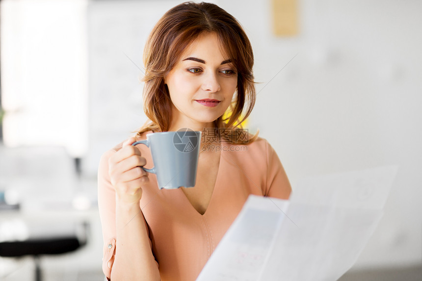 商业人的工作办公室文件喝咖啡的女商人女商人着报纸办公室喝咖啡图片