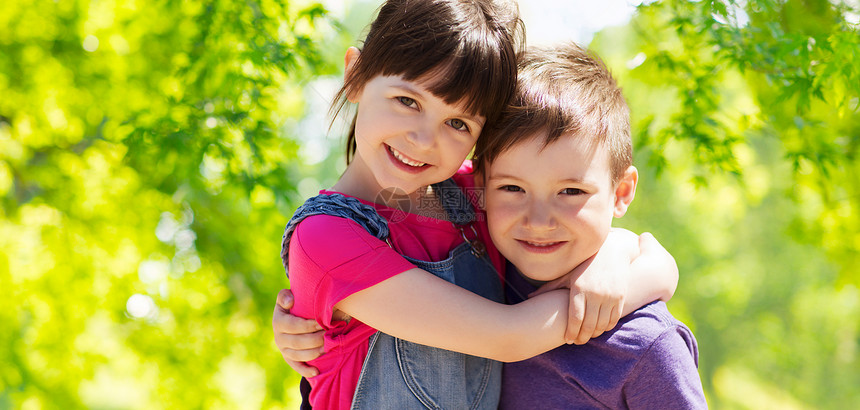 童,友谊家庭两个快乐的孩子拥抱绿色的自然背景快乐的孩子拥抱绿色的自然背景图片