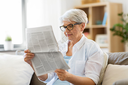 龄璃杯龄人的快乐的老妇女家看报纸老妇女家看报纸背景