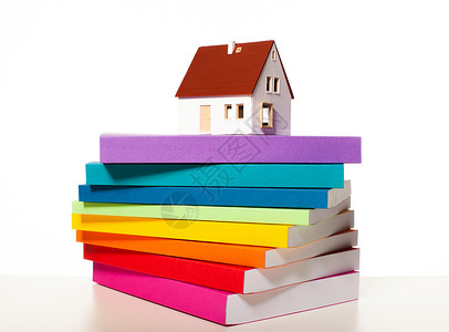 彩色晶格化房子的缩影叠彩色的书上,孤立白色的背景上建划的发展制定建划背景