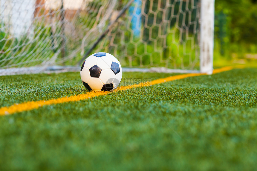 足球个球门网背景的足球人工场上人造草地上的足球图片