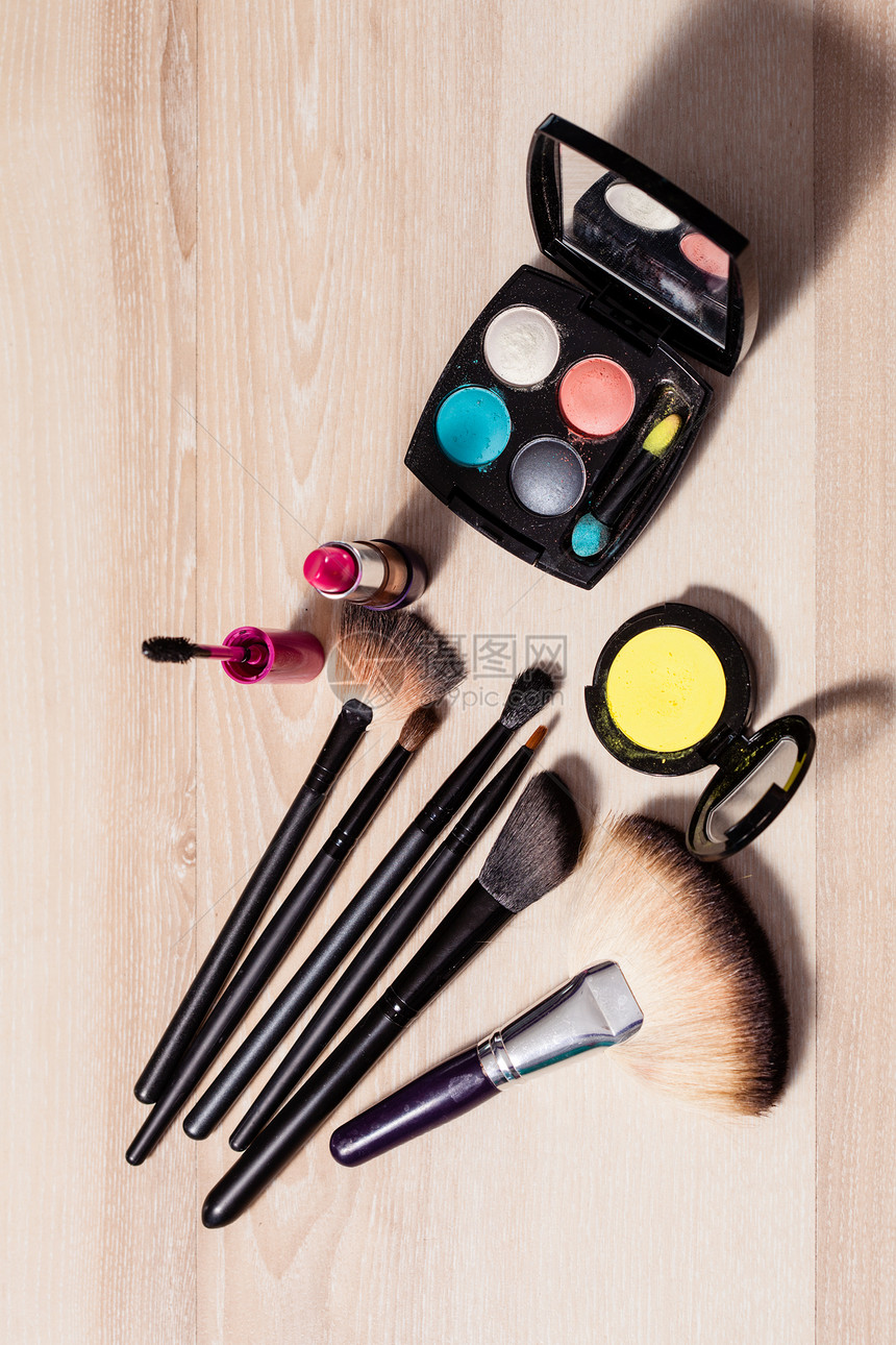 化妆木制桌子上的刷子化妆品,特写木制背景上的化妆品图片