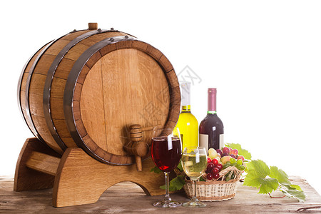 木制桌子和草地葡萄葡萄装瓶的葡萄酒靠近木桶桌上的杯酒,酒厂的红色白色酒庄的背景