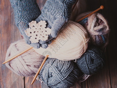 羊毛手套双手戴着灰色手套,着白色针雪花冬天的象征双手戴针手套背景