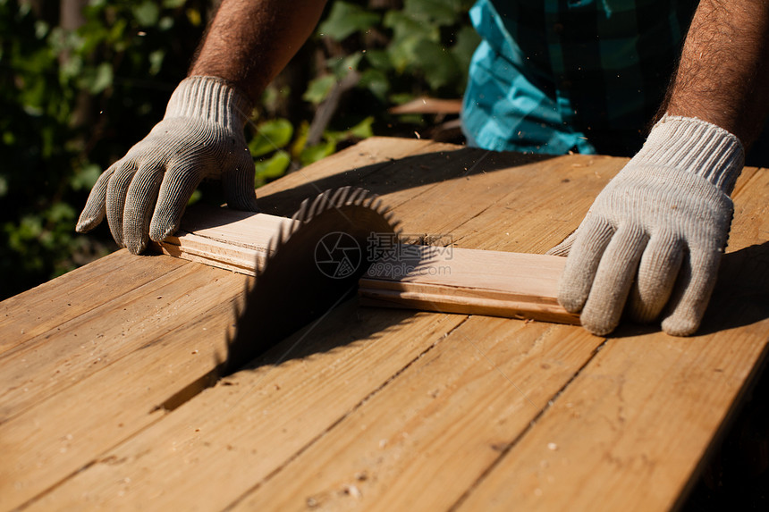 辛勤工作的木工切割木板,专注于锯锯木厂努力工作图片