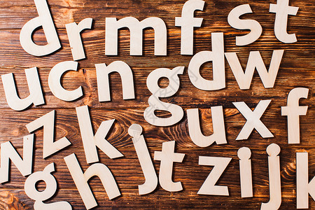字母表的大字母杂乱无章地散落木制背景上教育的散落的大字母图片