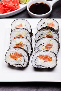 寿司卷白色盘子上寿司卷靠近图片