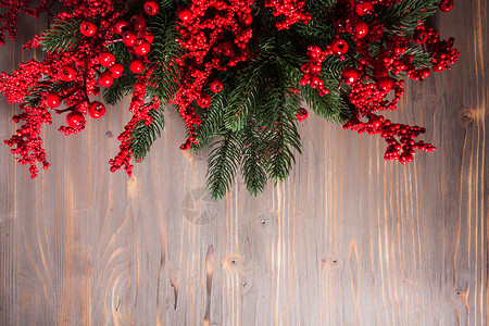 诞节冬青浆果树枝灰色冬青浆果树枝木墙上背景图片