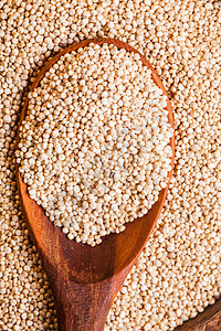 白色藜麦种子放木碗里的木勺子上堆藜麦颗粒高清图片