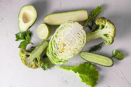 白色背景上切成两半的蔬菜的新鲜绿色成分排饮食图片