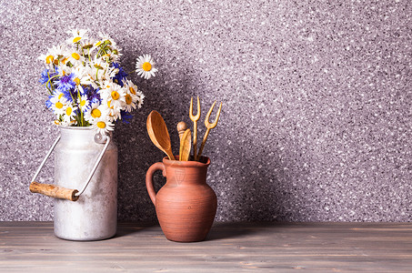 雏菊个老式的锡罐粗糙的陶瓷壶与木制炊具乡村装饰背景图片