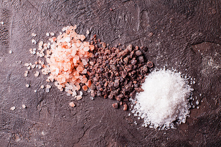 盐类各种盐,粉红色喜马拉雅山黑色与海盐石板背景各种盐的元背景