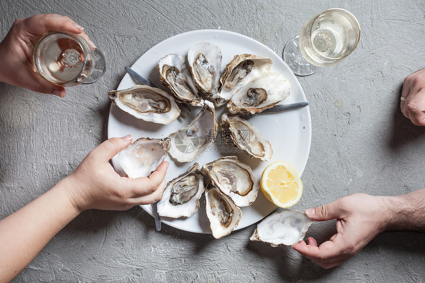 美味的牡蛎,柠檬片杯白葡萄酒,顶级景观异国风味的菜肴带葡萄酒的牡蛎图片