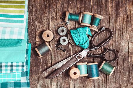 木制桌子上的复古剪刀纺品缝纫线蓝色复古缝纫高清图片