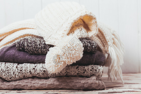 堆叠温暖的针毛衣,围巾帽子白色灰色的阴影羊毛衣服的收藏图片