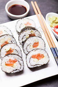 寿司卷白色盘子上寿司卷靠近图片
