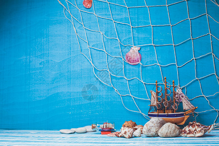 美丽的海洋成与玩具帆船,贝壳,璃瓶渔网蓝色背景海洋内部装饰背景图片