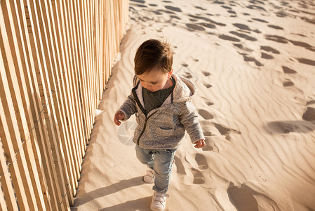 震波海滩上蹒跚学步的孩子蹒跚学步的孩子海滩上玩得很开心背景