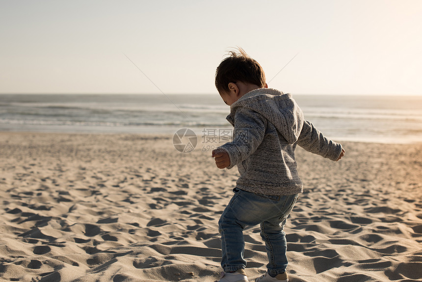 海滩上蹒跚学步的孩子蹒跚学步的孩子海滩上玩得很开心图片