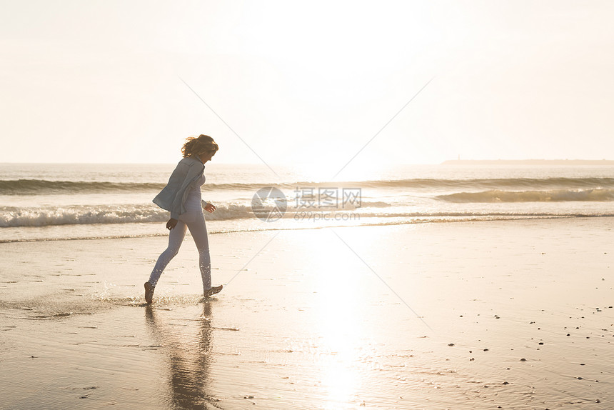 海滩上的女人美丽的女人海滩上享受日落图片