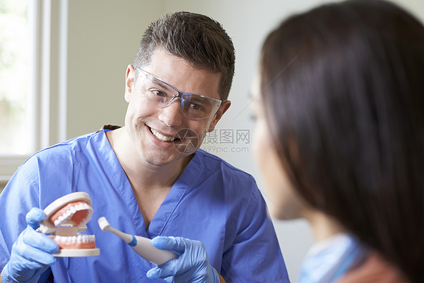 牙医向女客户演示用电动牙刷图片