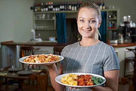 女服务员餐厅供应盘子的食物高清图片