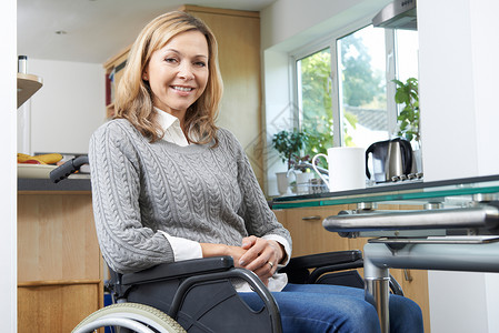 家庭轮椅上的成熟残疾妇女的肖像图片