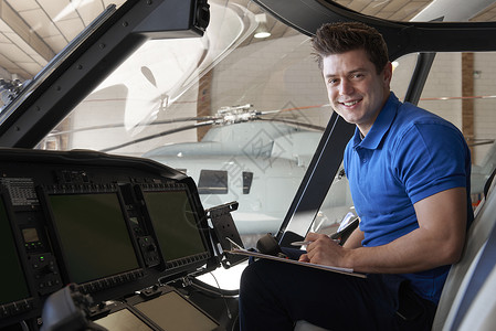 飞机库男航空工程师的肖像,剪贴板直升机驾驶舱工作背景